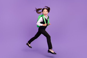 Fototapeta na wymiar Photo of glad cheerful impressed schoolgirl jump run wear bag uniform isolated violet color background