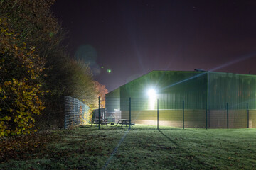 A bright security light on an warehouse on an industrial estate at night