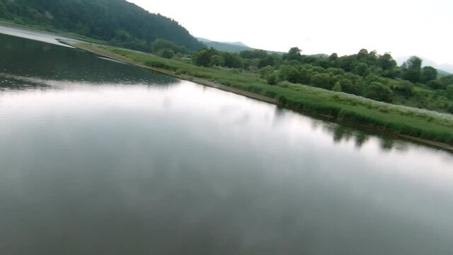 Wild ride in cinematic summer nature. POV drone shot of picturesque lake, wood trees and green landscape. Travel concept. Adventures, roadtrip.