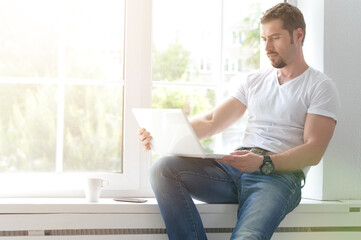 handsome young man with laptop at home