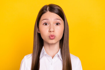 Photo of romantic affectionate schoolgirl send air kiss wear white shirt isolated yellow color background