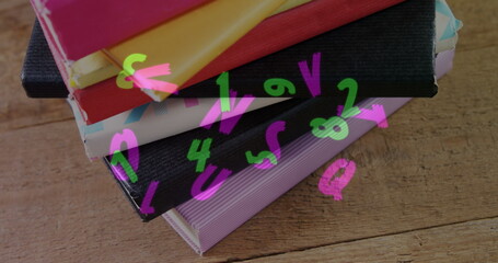 Obraz premium Digital composition of multiple changing alphabets and numbers floating against stack of books on wo