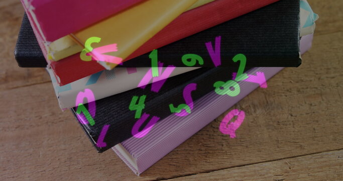 Digital composition of multiple changing alphabets and numbers floating against stack of books on wo