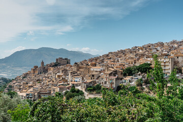 Fototapeta premium Caccamo, Sicily, Italy. View of popular hilltop medieval town with impressive Norman castle and surrounding countryside.Italian landscape.Picturesque village on hill with mountains in background.