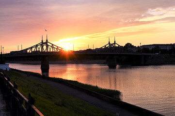 Urban landscape and a beautiful sunset in the evening on the river with a bridge in the background. Copy space