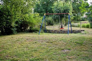 Swing on chains for children standing on the grass 