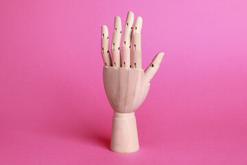 Wooden hand model on pink background. Mannequin part
