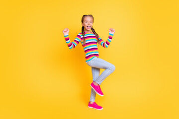 Fototapeta na wymiar Photo of cheerful astonished lady celebrate victory wear striped shirt jeans shoes isolated yellow color background