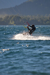 Fototapeta premium man in a wetsuit doing kitesurfing in a lake in Patagonia