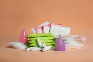 Menstrual pads and other period products on pale orange background - obrazy, fototapety, plakaty