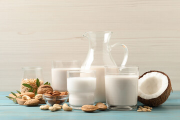 Different nut milks on light blue wooden table