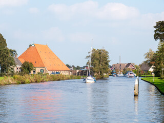 Fototapeta premium People on sailboat cruising on river Boorne in Akkrum, Friesland, Netherlands