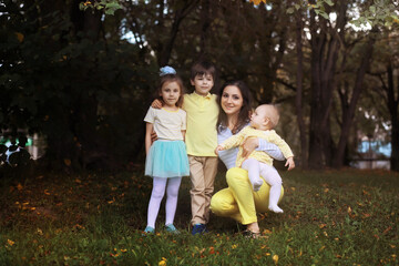 Fototapeta premium Family with children for a walk in the summer park. Сoming autumn&nbsp;in the park. Family. Fall. Happiness.