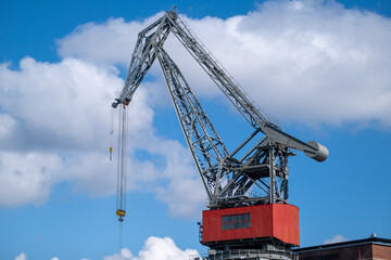 Fototapeta na wymiar Closeup of an old decomissioned harbor crane against vivid sky.