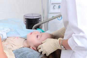 Obraz premium Preparing a child for surgery under general anesthesia. Hands in protective gloves. Artificial lung ventilation apparatus.