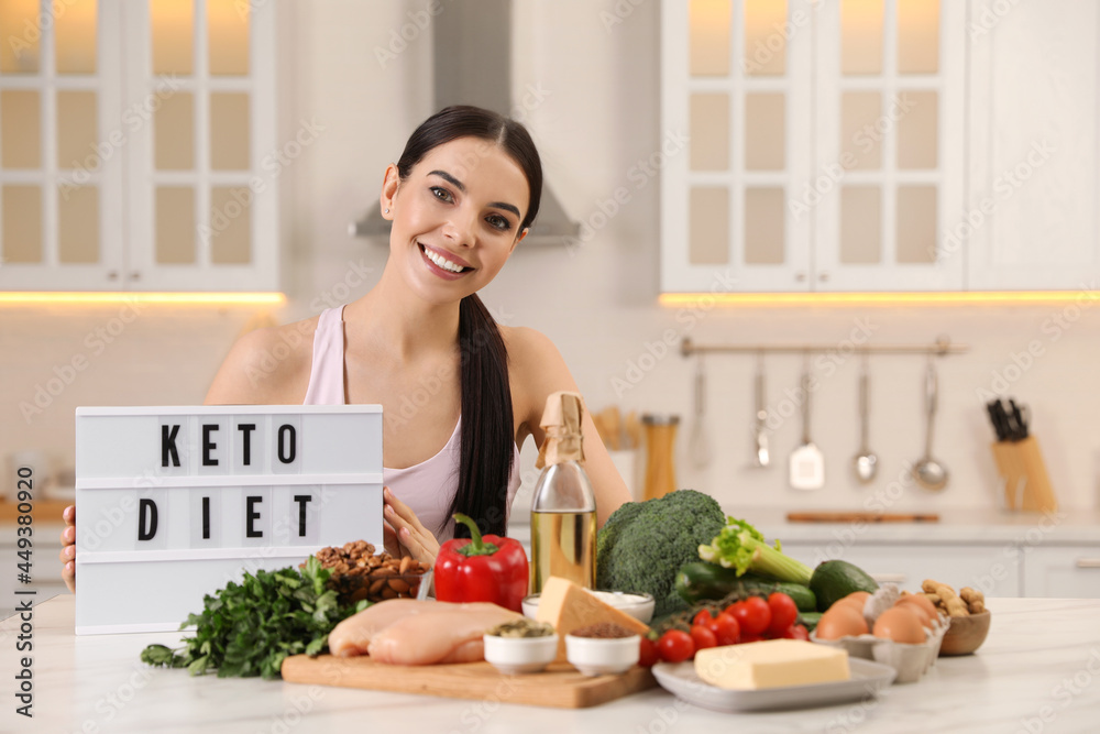 Canvas Prints Happy woman near lightbox with words Keto Diet and different products in kitchen