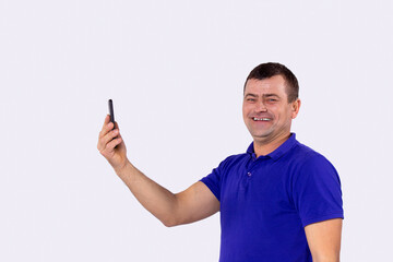 Adult man with hearing aid standing holding a telephone in his hand and he is happy to hear and talking to the phone call.