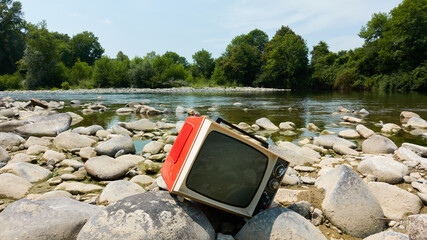 Old red TV abandoned outdoors in nature like garbage
