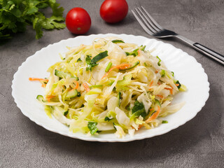 salad with cabbage and cucumber and carrots on a white plate
