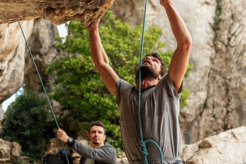 Young Caucasian climber prepares to start his climb to the top of a mountain.