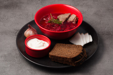 traditional Russian and Ukrainian soup-borscht with black bread, bacon and sour cream