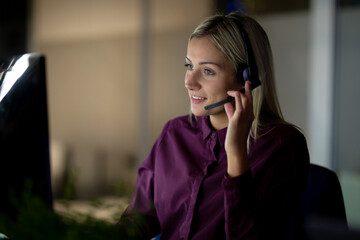 Caucasian businesswoman working at night wearing headset
