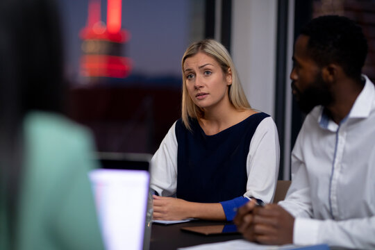 Diverse group of business colleagues working at night having meeting