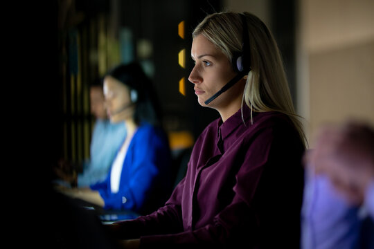 Caucasian businesswoman working at night wearing headset