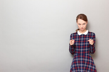 Portrait of serious young woman pointing with index fingers at you