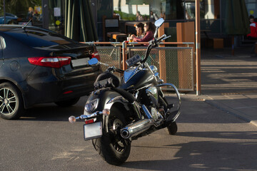 A motorcycle in the parking lot. The motorcycle is on the street.