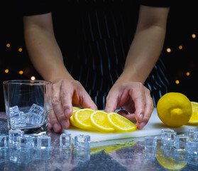 man intend to catch fresh slice lemon on cutting board near lemon, ice