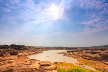 wonderfull sunlight of sun and cloud on sky above small lake surrounding with stone on mountain