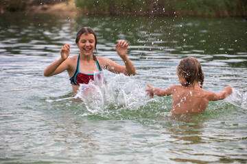 happy cheerful girls teenager splashes in water on vacation, horizontal