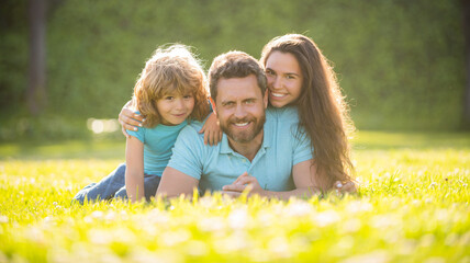 Fototapeta premium adoption and charity. family day. friendship. father mother and child on green park grass.
