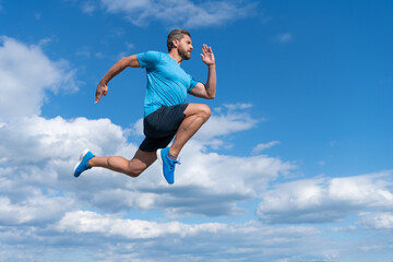 Obraz premium energetic man athlete with muscular body run in sportswear outdoor on sky background, endurance