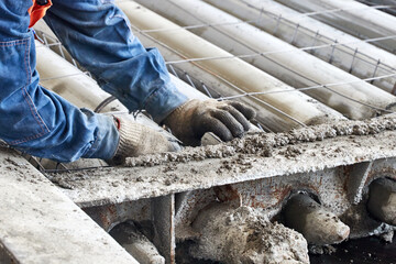 worker installing reinforcement into form of floor slabs