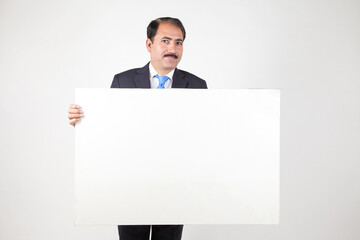 Mature business man holding blank placard banner