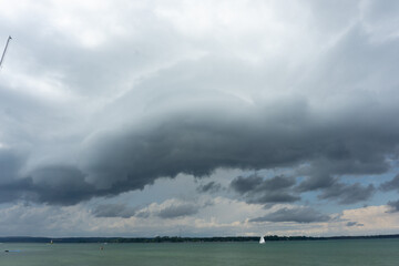 White drifting clouds over a clear blue lake