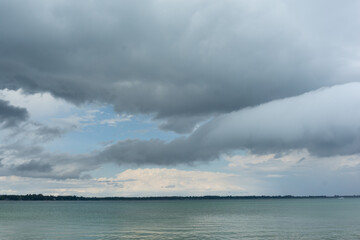 Naklejka na ściany i meble White drifting clouds over a clear blue lake