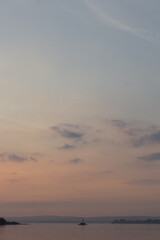 magenta sky with blue clouds over a clear magenta lake