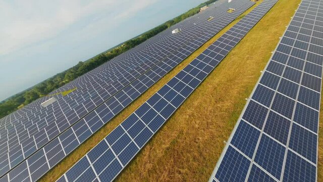 Aerial POV flight over huge ecological sustainable solar station. Many photovoltaic solar panel rows on agricultural rural field landscape. FVP drone.