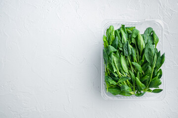 Washed fresh mini spinach, on white background, in plastic pack, top view flat lay , with space for...