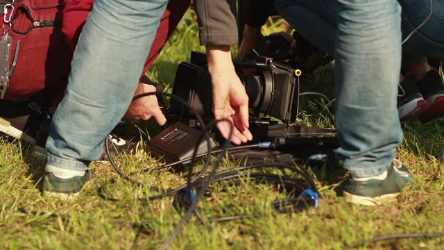 Film crew prepares and adjusts digital cinema camera for shooting of movie. DOP. Director of photography. Movie cinema production. Stage, scene. On set. Cinematography and videography. Rental concept