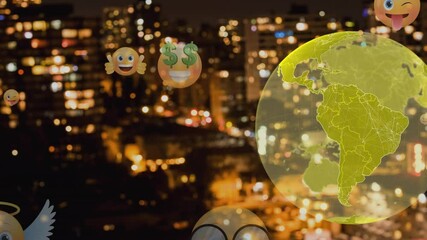 Spinning globe and multiple face emoji icons floating against aerial view of cityscape at night
