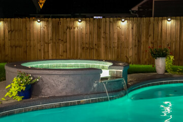 A backyard swimming pool and jacuzzi hot tob at night - obrazy, fototapety, plakaty
