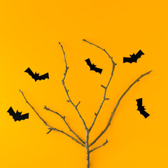 Tree with silhouettes of bats on an orange background. Flat bed. Halloween concept.
