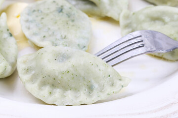 Green dumplings with spinach on the plate.