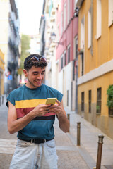 Young caucasian man with false nails using the phone on a street.