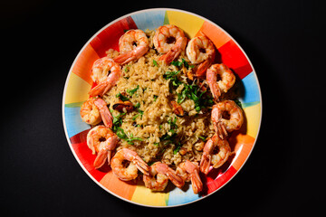 Risotto with mussels and shrimps on a colorful beautiful plate