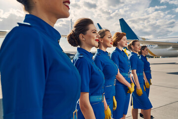 Group of young attractive stewardesses gazing into the distance